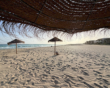 Royal Horizon Ponta Sino rieten parasols op het strand tijdens zonsondergang