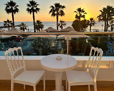 Fafa Premium Albanië zitje op het balkon met uitzicht op palmbomen en zee