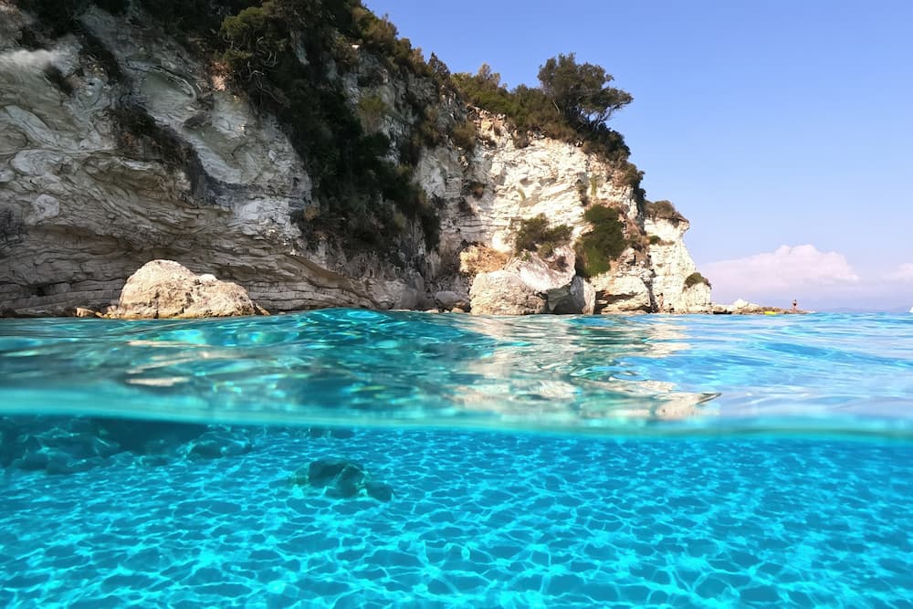 Helder water Antipaxos Griekenland bij Voutoumi strand half onder water half boven water