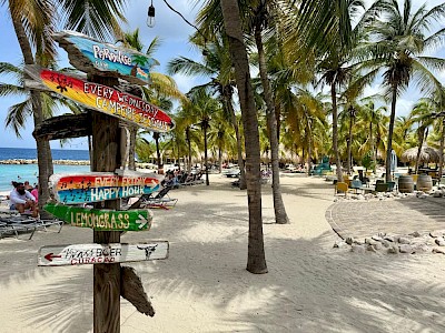 Blue Bay Curaçao wegwijsbord en palmbomen op het strand