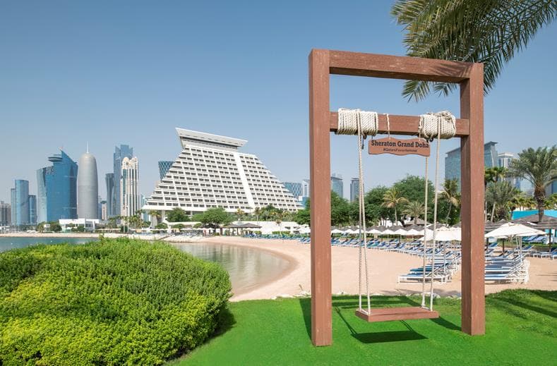 Schommel met uitzicht op het strand en wolkenkrabbers bij Sheraton Grand Doha Qatar