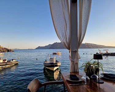 Restaurantje op Santorini aan het water met bootjes